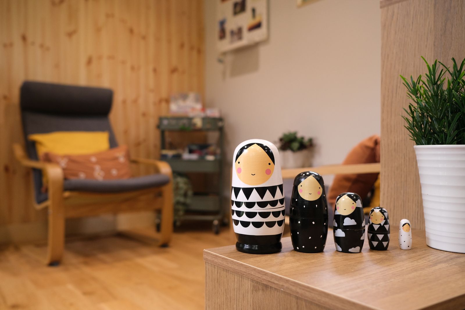 A set of black and white nesting dolls lined up on a low table in the counselling room